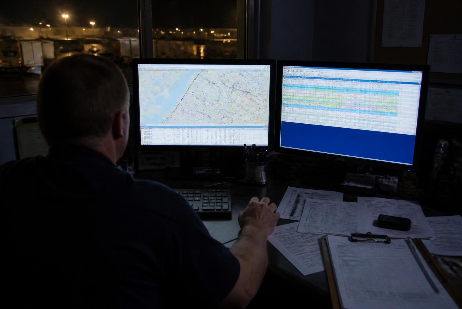 Freight dispatch office with route planning screens at night